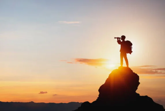 頂上の人物、双眼鏡で遠くを見る