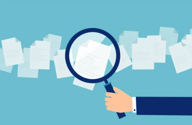 書類を虫眼鏡で確認する手