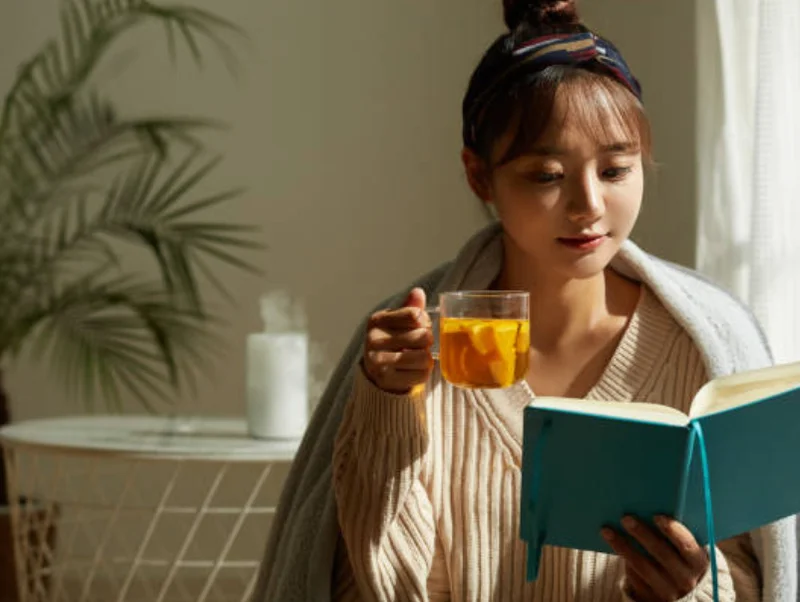 HSPな女性が読書しながら温かい飲み物を飲む